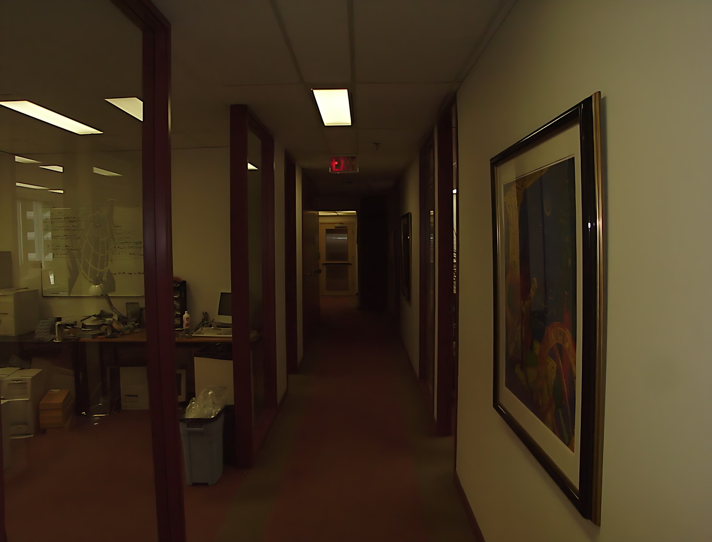 Long, narrow hallway with a red carpeted floor and white walls