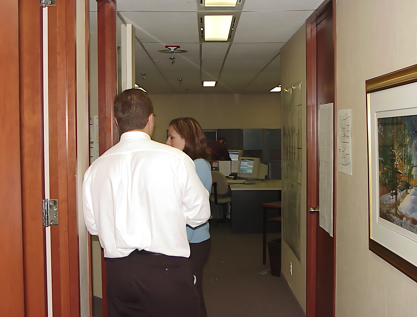 Man and a woman walking down a hallway in an office