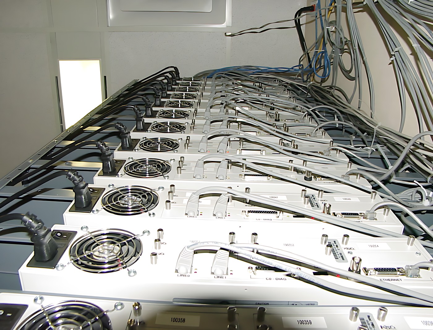 Rack of multiple electronic devices with multiple wires and cables conne