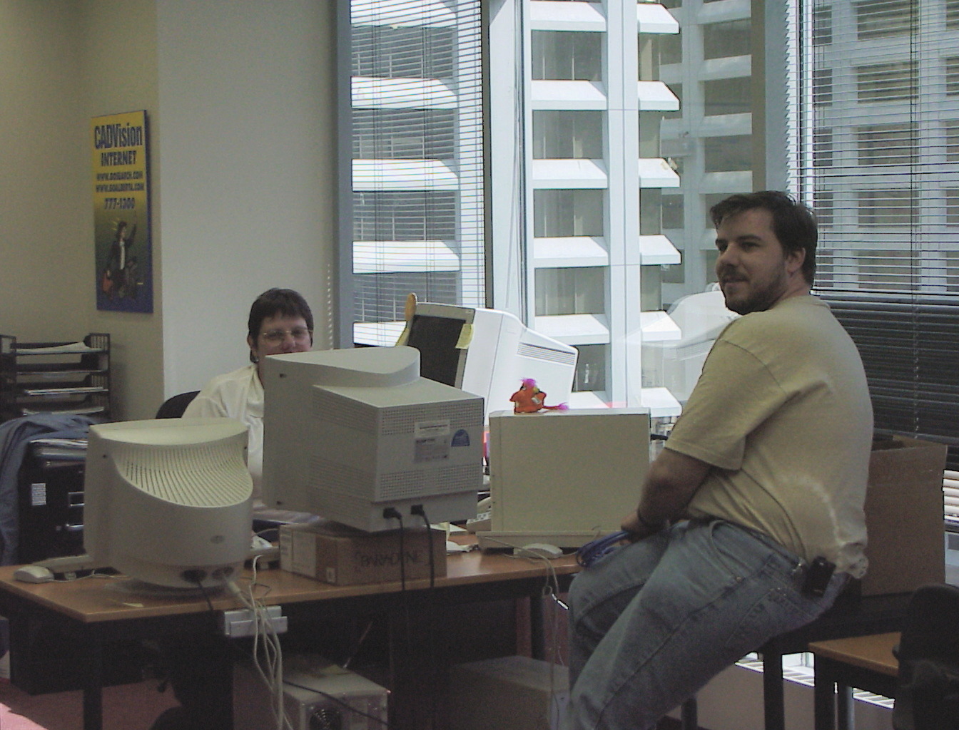 Among the monitors — a CADVision poster on the wall
